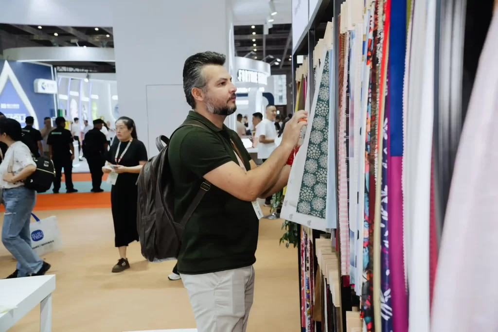 Representante da City Comex analisa amostras de tecidos premium | feira Intertextile Shanghai 2026